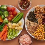 Vibrant display of assorted vegetables, legumes, nuts, and seeds on plates, perfect for healthy eating images.